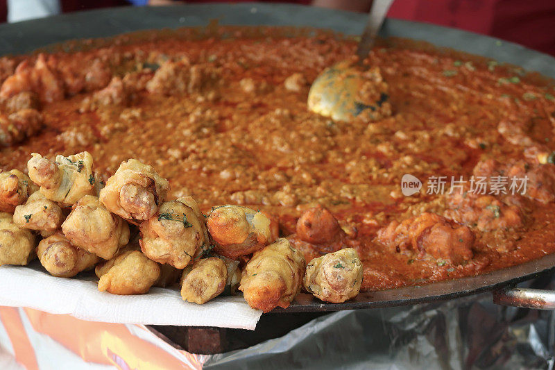 广受欢迎的快餐菜品Pav bhaji(咖喱蔬菜)和炸丸子(炸丸子)的自助宴会餐盘形象，聚焦前景